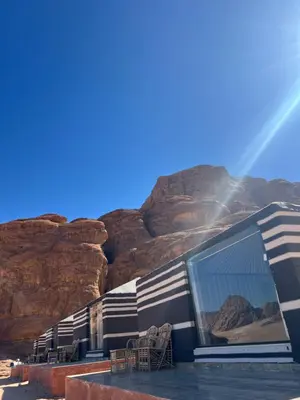 a building with a mountain in the background at Wadi Rum Mars Camp in Wadi Rum