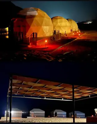 a view of three domes in a field at night at Wadi Rum Mars Camp in Wadi Rum