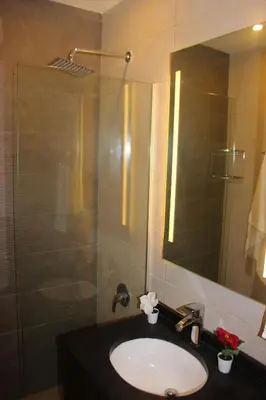 a bathroom with a sink and a shower with a mirror at New MerryLand Hotel in Amman