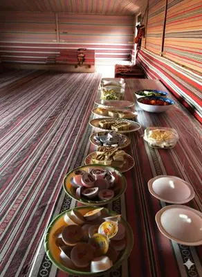 a long table with plates of food on it at One Thousand and One Nights Camp in Wadi Rum