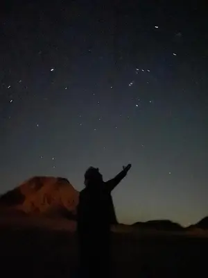 a person pointing to the stars in the night sky at Rum Panoramic Camp & Tour in Wadi Rum