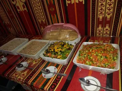 three trays of different types of food on a table at Rum Panoramic Camp & Tour in Wadi Rum