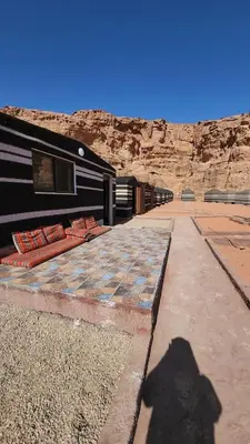 a shadow of a person standing in front of a building at Real Bedouin life &tour in Wadi Rum