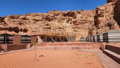 a building in front of a rocky mountain at Real Bedouin life &tour in Wadi Rum