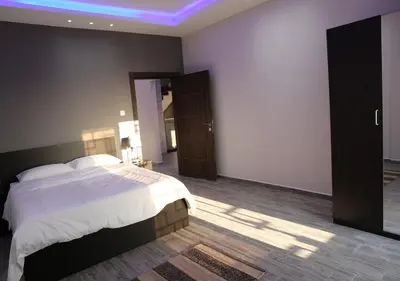 a bedroom with a large bed and a blue light at Dar Gerasa chalets - شاليهات دار جراسا in Jerash