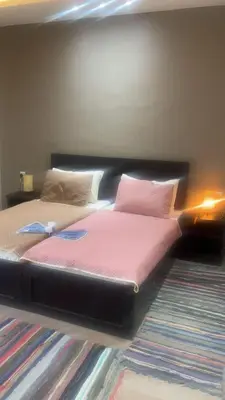 a bed with pink sheets and pillows in a room at Dar Gerasa chalets - شاليهات دار جراسا in Jerash