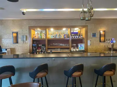 a bar with stools in front of a counter at O Beach Hotel & Resort in Sowayma