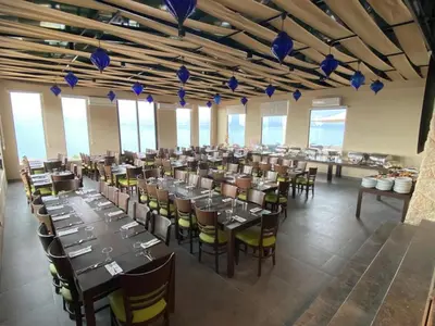 a dining room with tables and chairs and blue glasses at O Beach Hotel & Resort in Sowayma