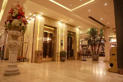 a lobby with a large vase with flowers in it at Strand Hotel Jordan in Amman