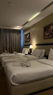 a hotel room with three beds in a room at Strand Hotel Jordan in Amman