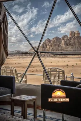 a room with a view of the desert through a window at WADI RUM TARA lUXURY CAMP in Wadi Rum
