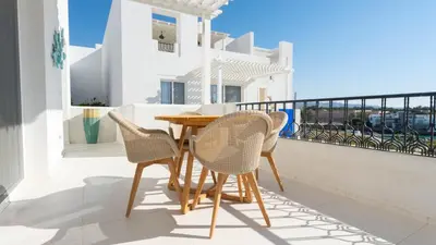 a table and chairs on the balcony of a house at Cloud 7 Residence Ayla Aqaba in Aqaba