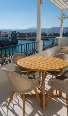 a wooden table and chairs on a balcony at Cloud 7 Residence Ayla Aqaba in Aqaba