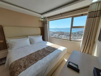 a bedroom with a bed and a large window at Jordan Seasons Hotel in Aqaba