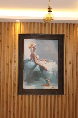 a painting hanging on a wall with a light at Post Boutique Hotel Amman in Amman