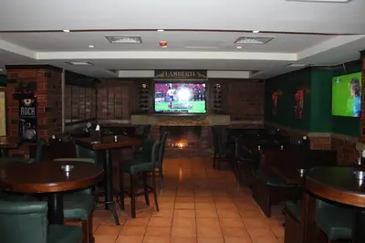 a bar with tables and chairs and televisions at Post Boutique Hotel Amman in Amman