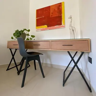 a desk with a chair and a painting on the wall at Nu Fifty Two in Amman