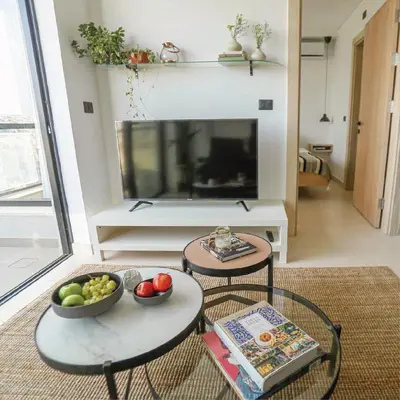 a living room with two tables and a flat screen tv at Nu Fifty Two in Amman