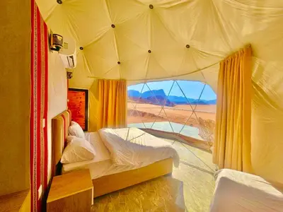 a bedroom with a tent with a view of the desert at NAEL BEDOUIN lUXURY CAMP in Wadi Rum