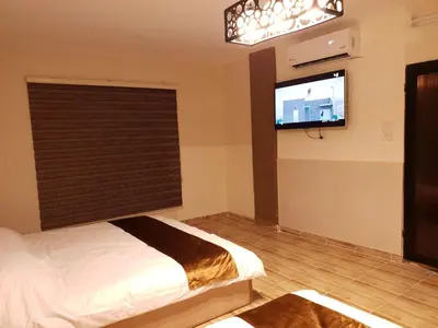 a bedroom with a bed and a flat screen tv at atoom studio in Jerash