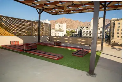 a patio with red benches on the grass at Hakaia Community in Aqaba