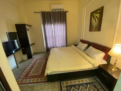 a small bedroom with a bed and a television at City Citadel Hotel,Amman in Amman