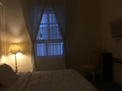 a bedroom with a bed and a window and a lamp at City Citadel Hotel,Amman in Amman
