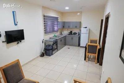 a small kitchen with a stove and a refrigerator at Dali House in Amman