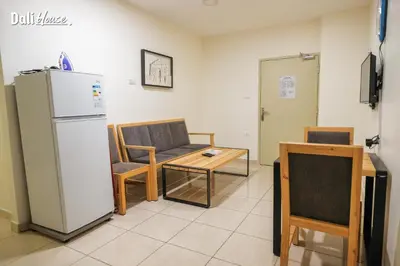 a room with a refrigerator and a table and a chair at Dali House in Amman