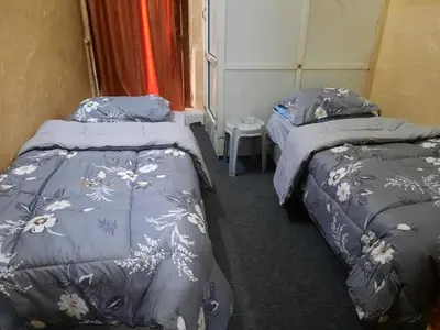 a room with two beds and a table at Al Naser Hotel in Amman
