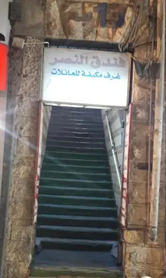 a stairway leading up to a building with a sign at Al Naser Hotel in Amman