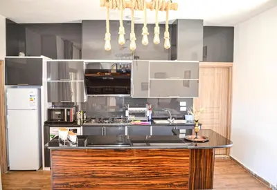 a kitchen with a black counter top and a refrigerator at VILLA MARIA PETRA in Wadi Musa