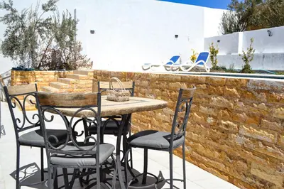 a table and chairs on a patio next to a brick wall at VILLA MARIA PETRA in Wadi Musa