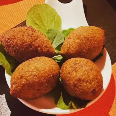 a plate of food with four food balls on a table at Mount Nebo Hotel & Restaurant Madaba City Center in Madaba