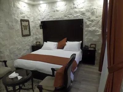 a hotel room with a bed and a chair at Mount Nebo Hotel & Restaurant Madaba City Center in Madaba