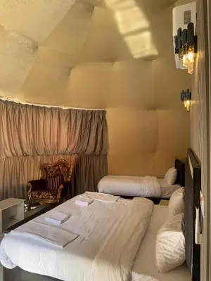 a room with two beds and a chair at Wadi Rum Marcanã camp in Aqaba