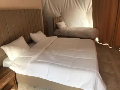a bedroom with two beds with white sheets and pillows at Wadi Rum Marcanã camp in Aqaba