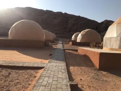 a row of domed buildings in the desert at Wadi Rum Marcanã camp in Aqaba