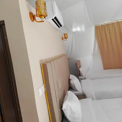 a room with two beds and a light on the wall at Wadi Rum Marcanã camp in Aqaba
