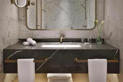 a bathroom with a sink and a mirror and towels at Signia by Hilton in Amman