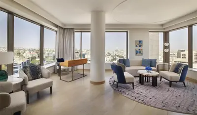 a living room with furniture and large windows at Signia by Hilton in Amman