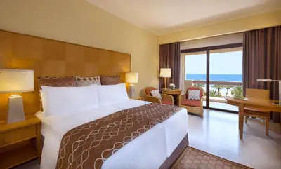 a hotel room with a bed and a view of the ocean at InterContinental Aqaba by IHG in Aqaba