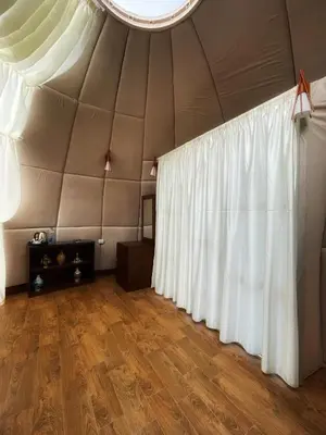 a tent with white curtains and a wooden floor at Rum Oasis Luxury Camp in Wadi Rum