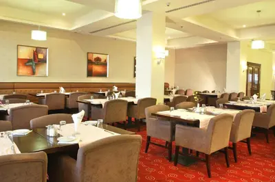 a restaurant with tables and chairs in a room at Grand Palace Hotel in Amman