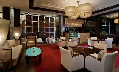 a restaurant with white chairs and tables and a bar at Crowne Plaza Amman by IHG in Amman