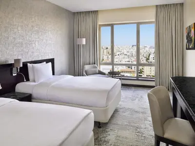 a hotel room with two beds and a window at Mövenpick Hotel Amman in Amman