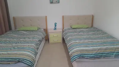 two beds sitting next to each other in a bedroom at Gorgeous Pool View Apartment - Tala Bay Resort, Aqaba in Aqaba