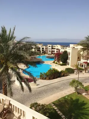 a view of the pool from the balcony of a resort at Gorgeous Pool View Apartment - Tala Bay Resort, Aqaba in Aqaba