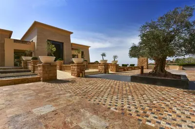 a house with a tree in the middle of a patio at Kempinski Hotel Ishtar Dead Sea in Sowayma