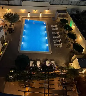 an overhead view of a swimming pool with tables and umbrellas at Salome Hotel in Madaba